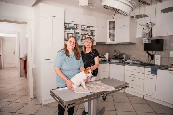 Zwei Tierärztinnen mit einem kleinen Hund auf dem Untersuchungstisch